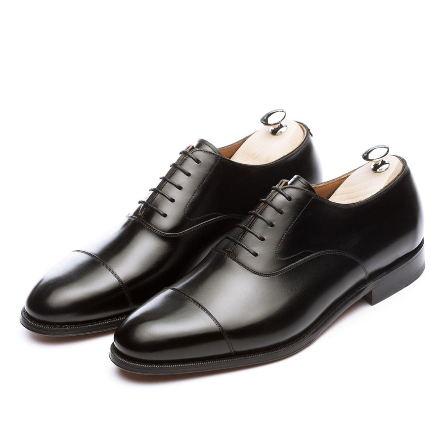 Meermin black boxcalf cap-toe Oxfords, front three-quarter view on shoe trees, showing closed channel leather soles