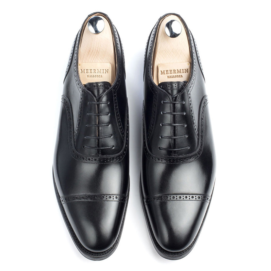 Meermin black boxcalf cap-toe Oxfords, top-down view on shoe trees showing brogue detailing on both shoes side by side
