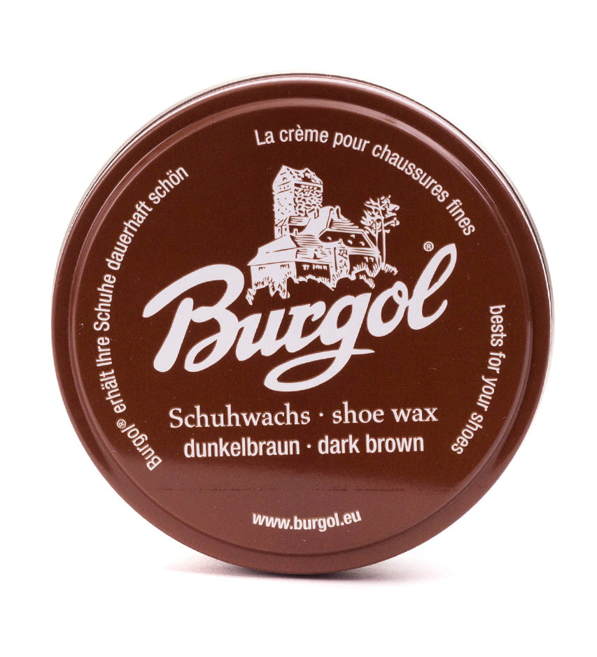 Top-down view of round Burgol dark brown shoe wax tin lid with castle emblem and multilingual text