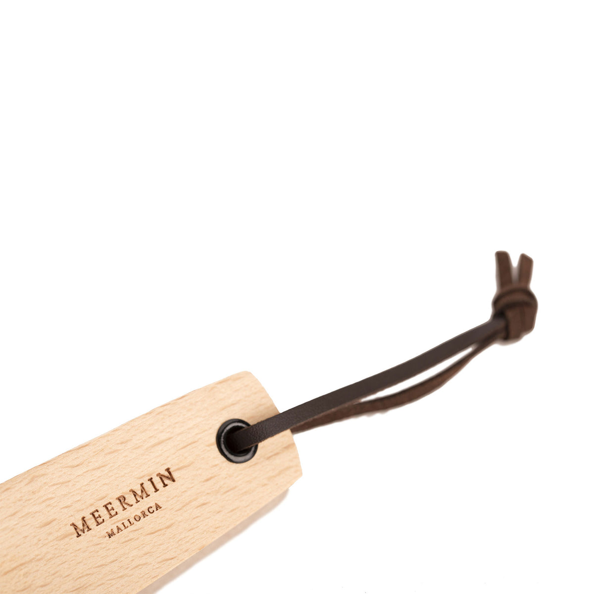 Close-up of Meermin beechwood shoe horn's grommet hole, with dark leather cord looped through for hanging