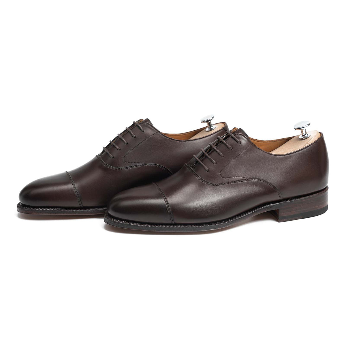 Meermin dark brown calfskin cap-toe Oxfords, pair shown angled with shoe trees inserted, showcasing Goodyear welted leather soles