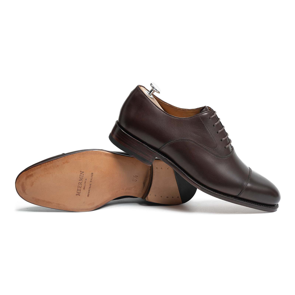 Meermin dark brown calf cap-toe Oxfords, one shoe upright with shoe tree, one shown sole-up displaying Goodyear welted leather sole
