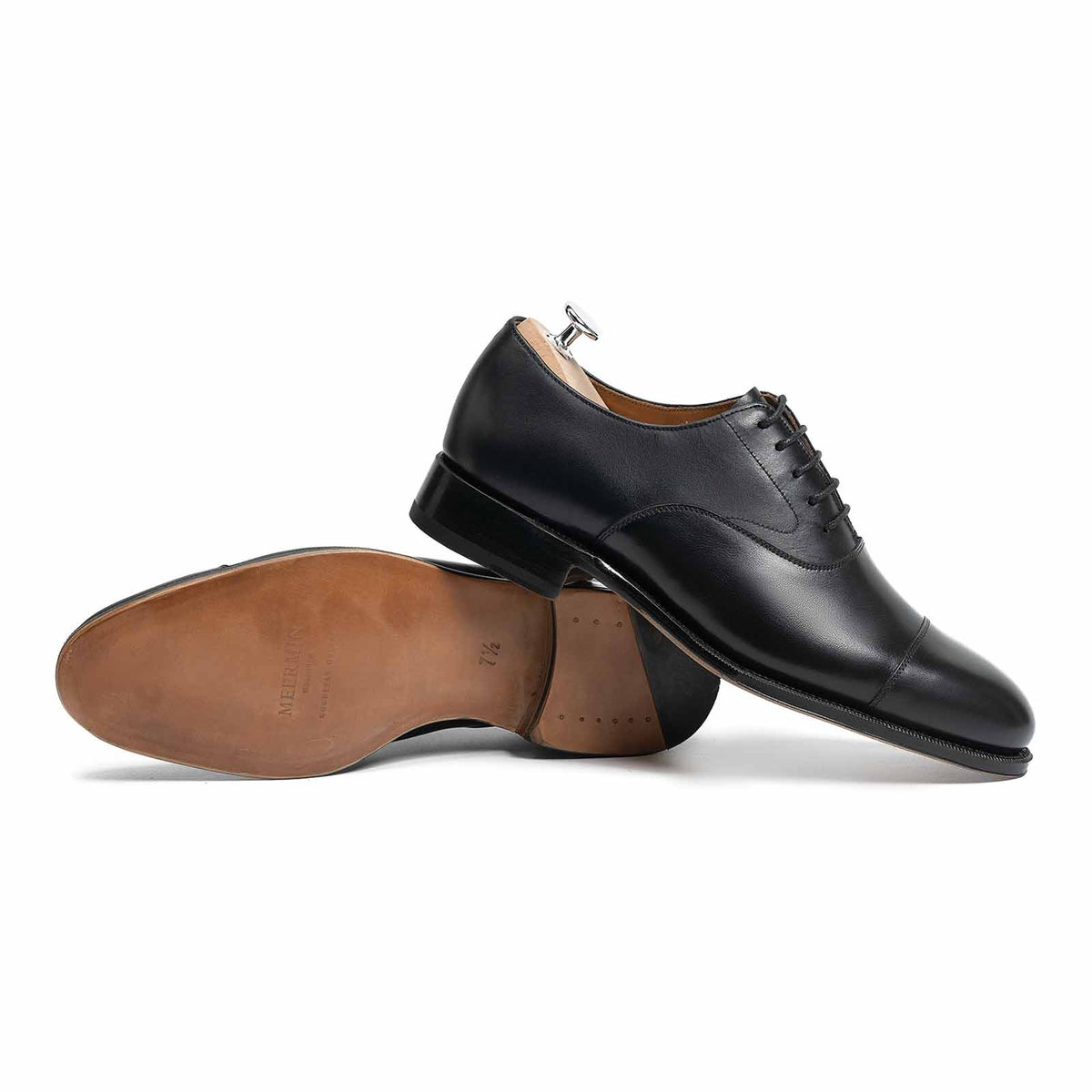 Meermin black boxcalf cap-toe Oxford pair, one shoe on its side showing sole and heel, one upright with shoe tree