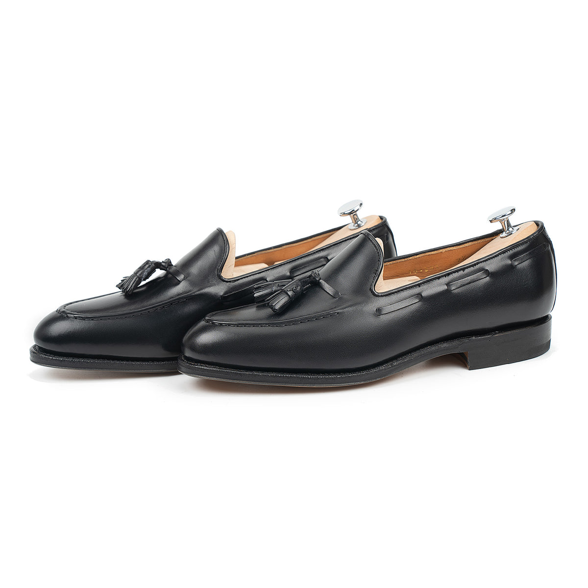 Meermin black boxcalf tassel loafers, three-quarter side view with shoe trees inserted, showing apron stitching and closed channel sole