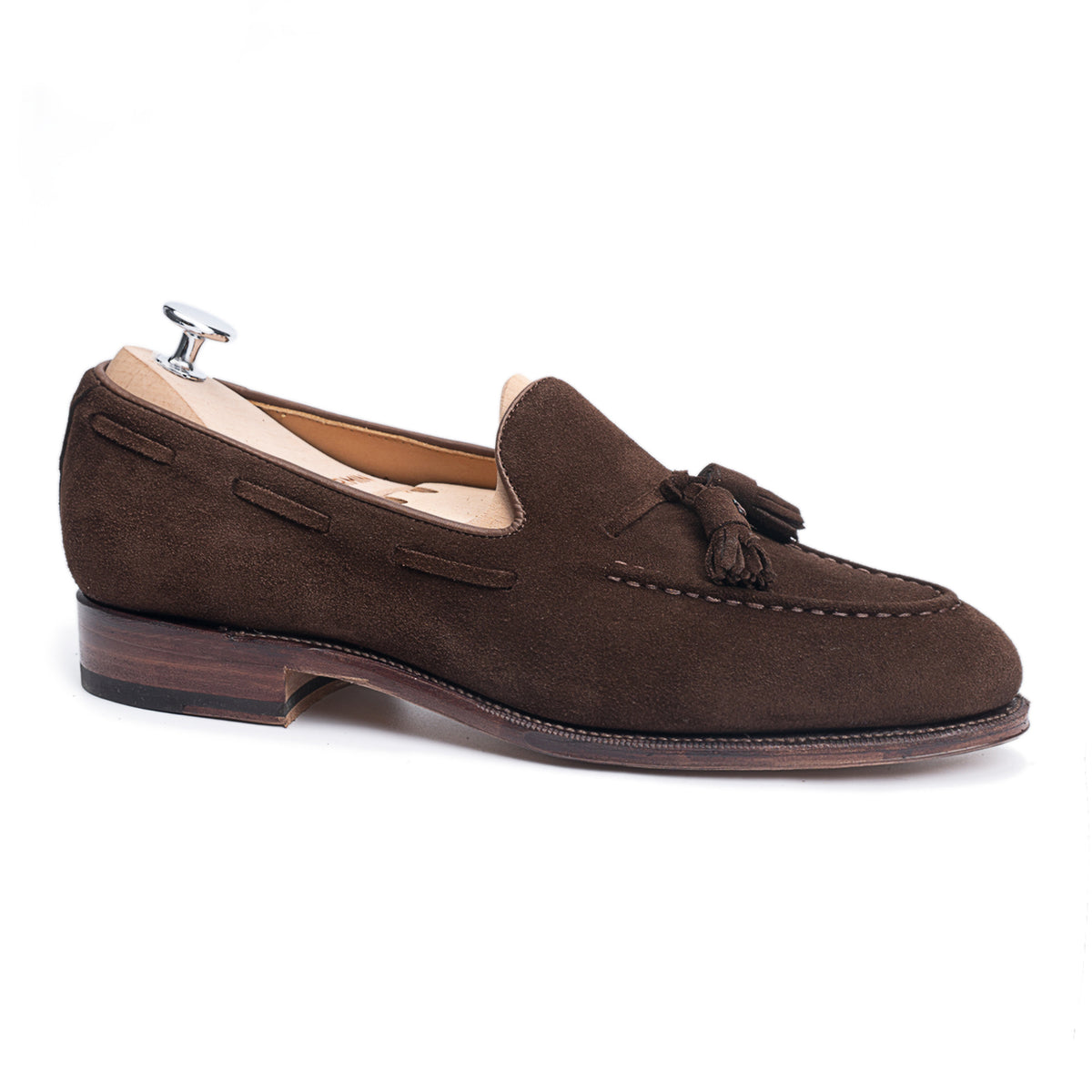 Meermin brown suede tassel loafer on a shoe tree, side profile showing hand-sewn apron and stacked leather heel