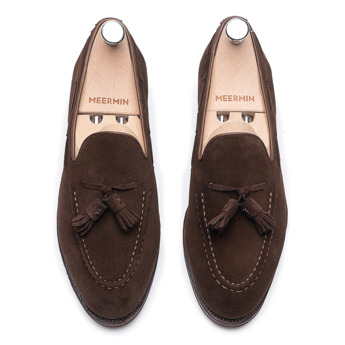 Meermin brown suede tassel loafers, top-down view on shoe trees, showing handsewn aprons and hand-closed tassels