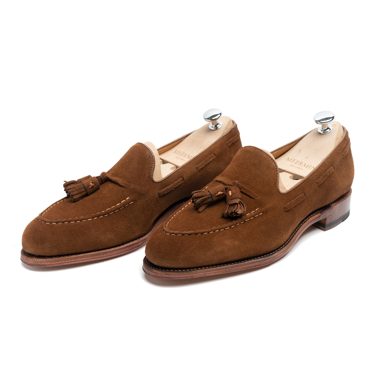 Meermin snuff suede tassel loafers, three-quarter front view on shoe trees, showing hand-sewn apron and tassel detail