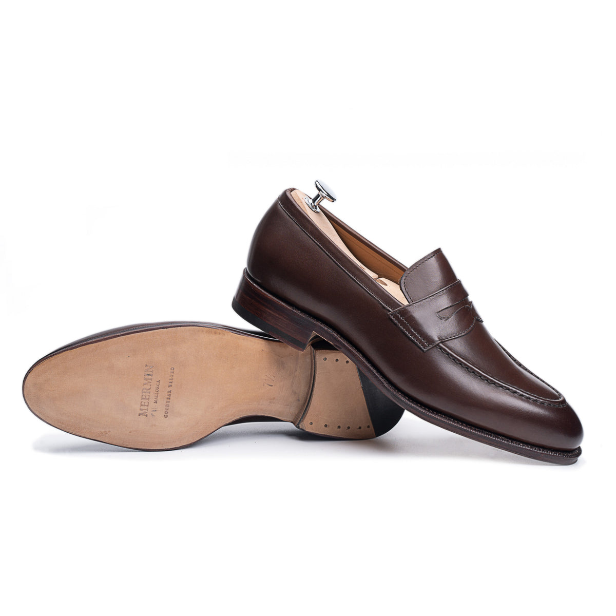 Meermin espresso calfskin penny loafer pair, one shoe on its side showing leather sole, the other upright with shoe tree