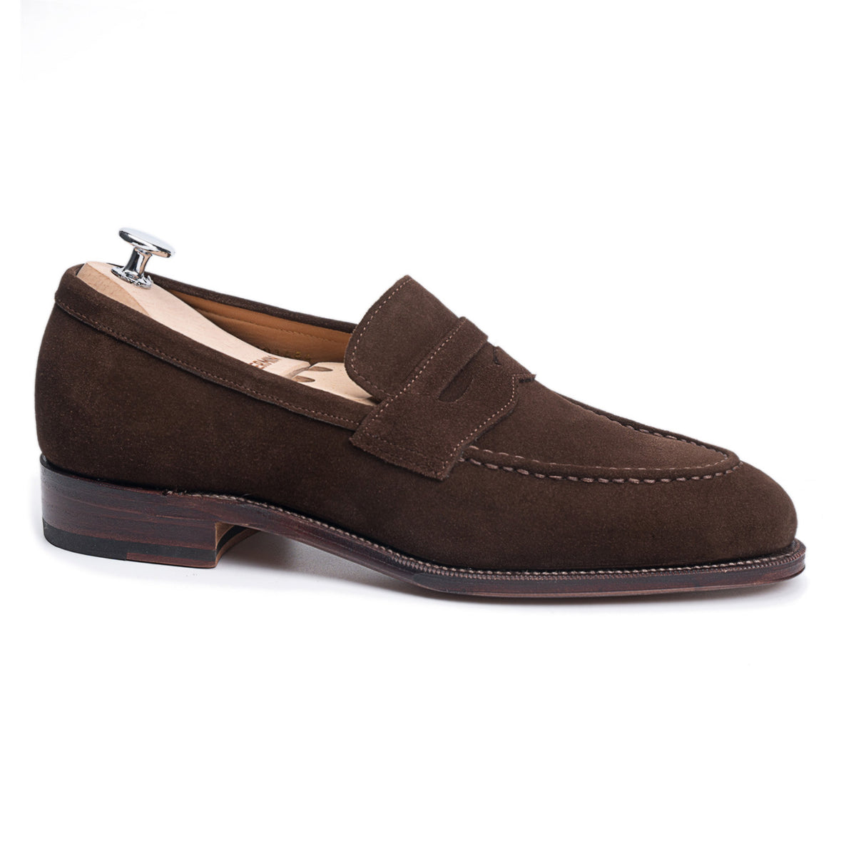 Meermin brown suede penny loafer, side profile on a shoe tree, showing apron stitching and stacked leather heel