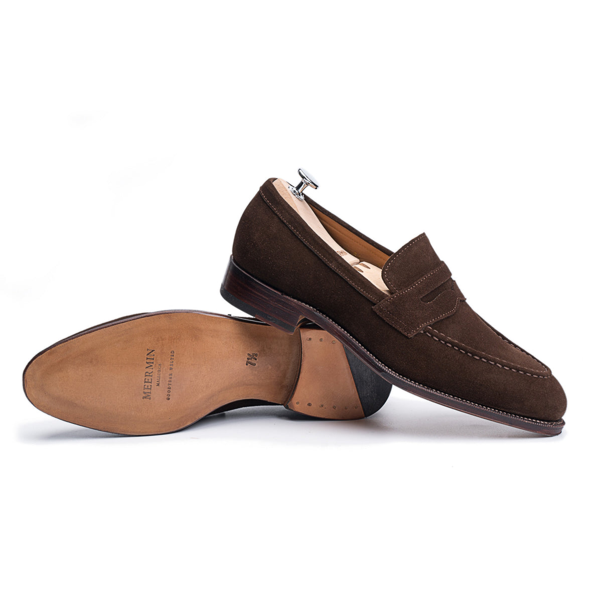 Meermin brown suede penny loafers, one shoe on shoe tree, the other tipped over showing leather sole and stacked heel