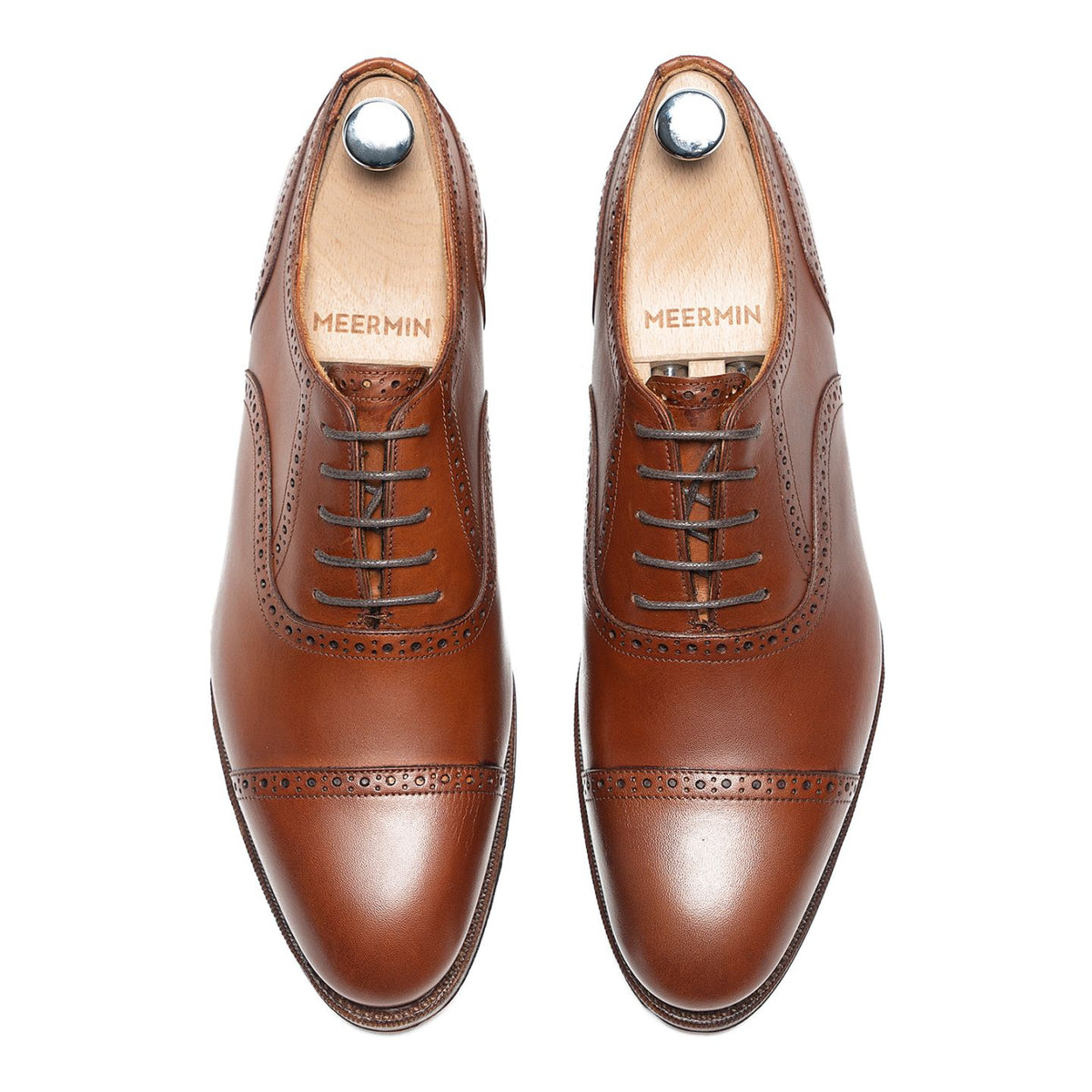 Meermin tan antique calf cap-toe Oxfords, top-down view of both shoes with shoe trees inserted, showing brogue detailing and lace pattern