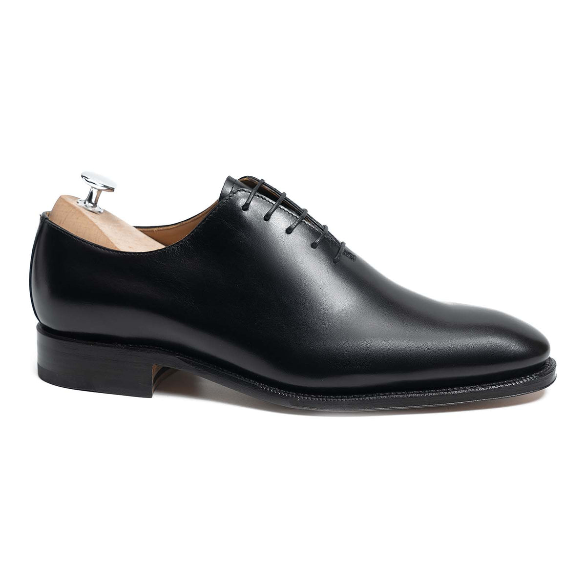 Meermin black boxcalf wholecut Oxford, side profile on shoe tree, showing sleek seamless upper and closed channel leather sole
