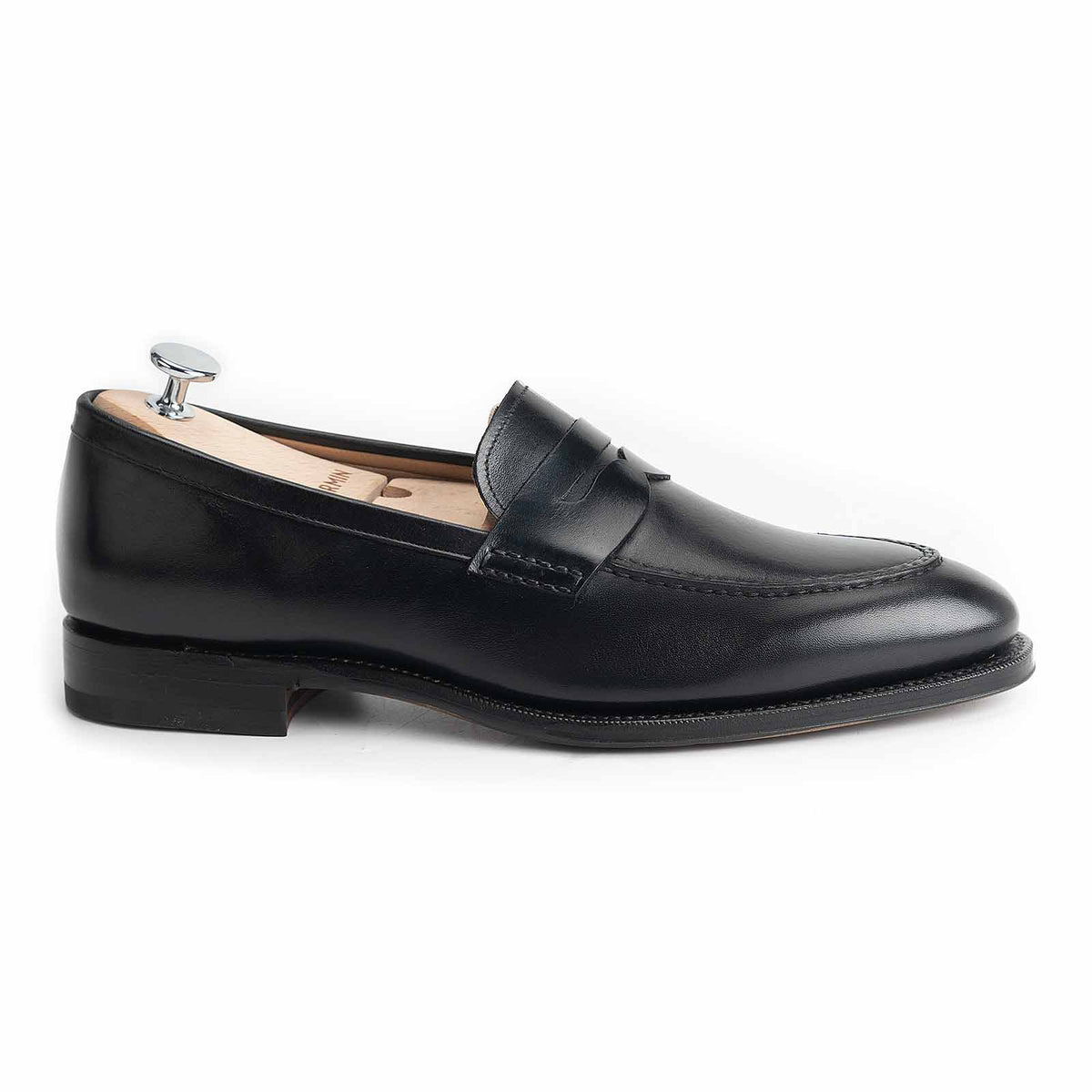 Meermin black boxcalf penny loafer, side profile with shoe tree inserted, showing apron stitch detail and leather sole