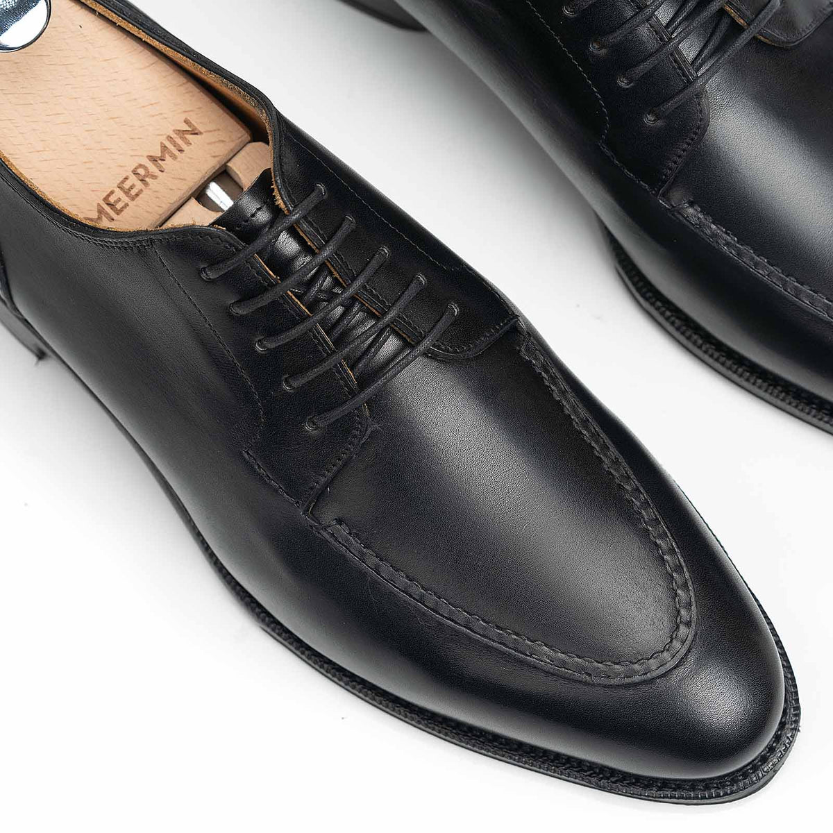 Close-up of Meermin black boxcalf Norwegian derby toe and lacing, with wooden shoe tree inserted, showing apron stitch detail