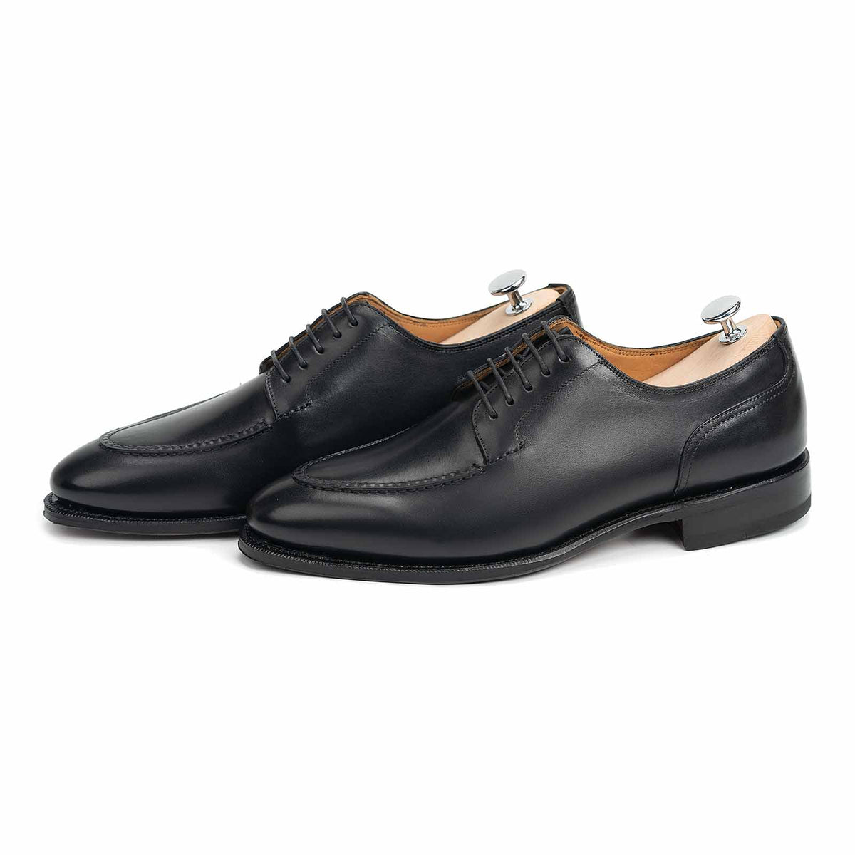 Meermin black boxcalf Norwegian derby pair, three-quarter side view showing apron stitch detail and closed-channel leather sole