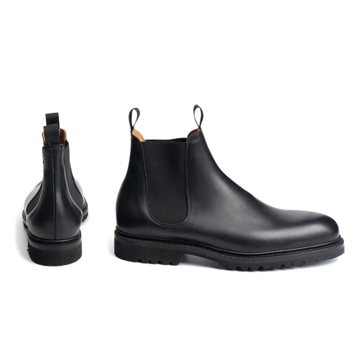 Meermin black boxcalf Chelsea boots, paired side and back view showing elastic gores, pull tabs, and cleated rubber sole