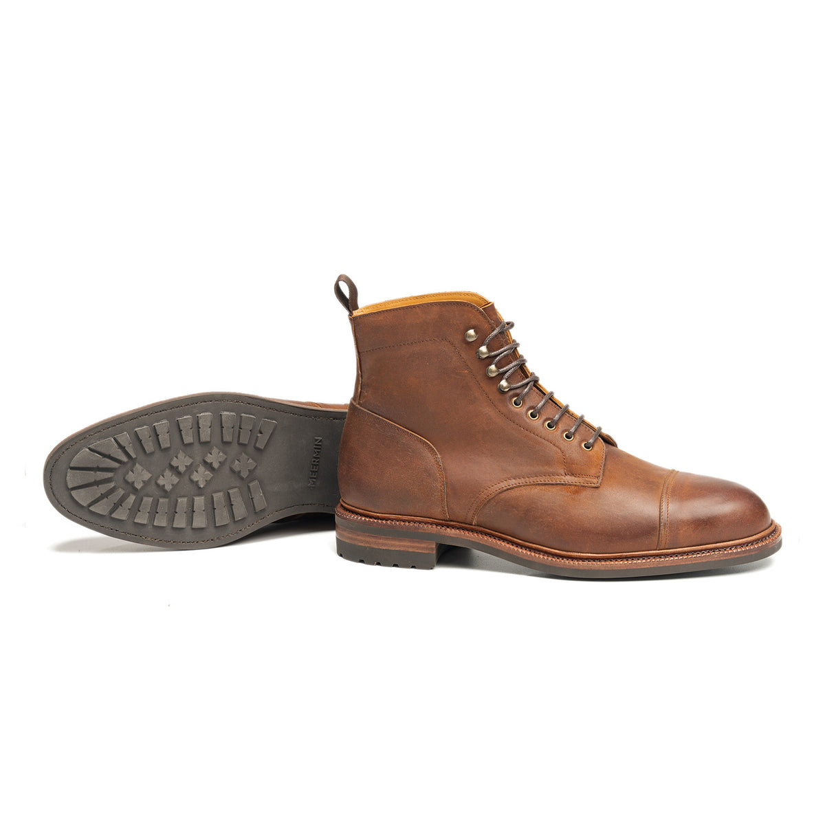 Meermin tobacco waxy shell cordovan cap-toe boot, side profile, paired with its sole shown tread-up beside it