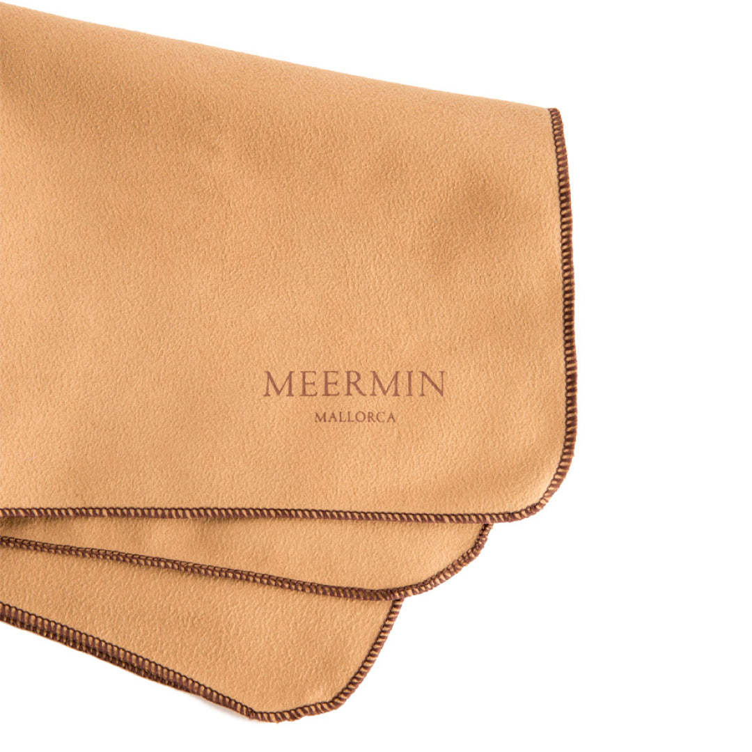 Close-up of folded Meermin microfiber polishing cloth in tan, showing stitched edge detail and embossed logo