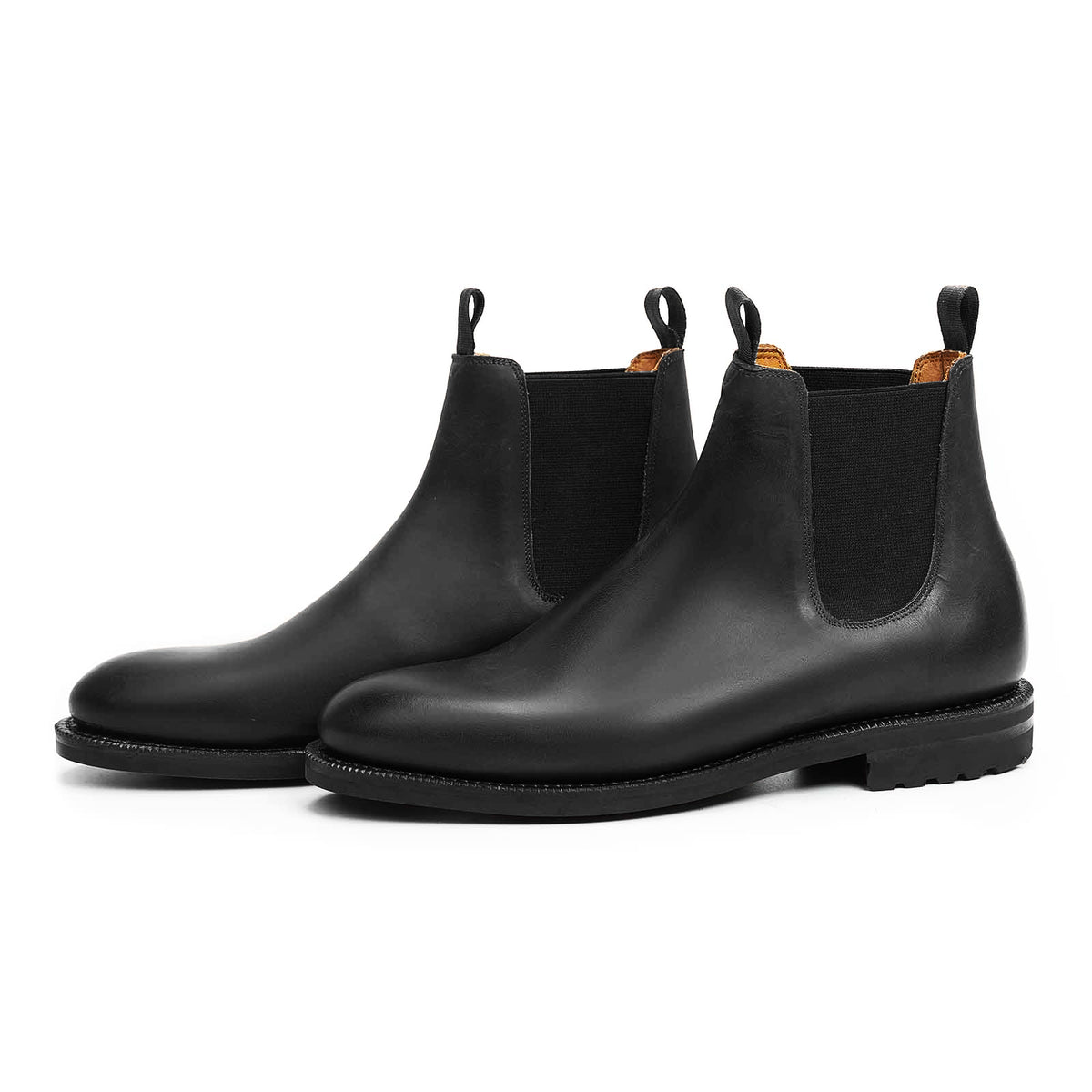 Meermin black waxy calf wholecut Chelsea boots, pair shown at angle showcasing elastic gussets and lugged sole
