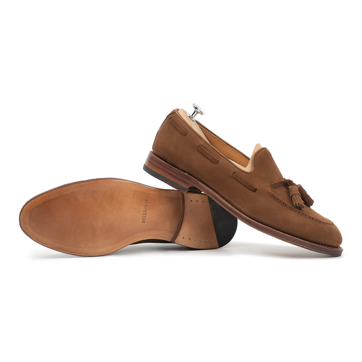 Meermin snuff suede tassel loafers, side profile pair with one shoe on tree, sole facing camera showing leather sole and heel stack