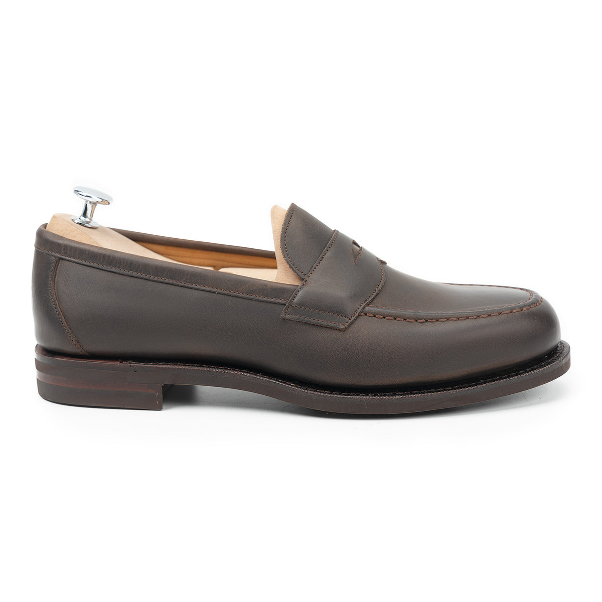 Meermin brown waxy calf penny loafer, side profile on shoe tree, showing apron stitching and studded rubber sole