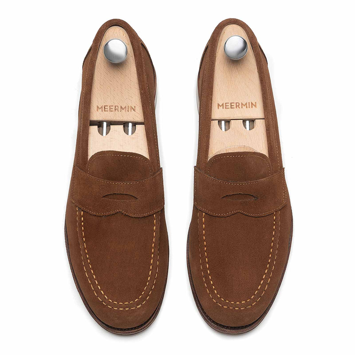 Meermin snuff suede penny loafers, top-down view on shoe trees, showing apron stitching and moc-toe detail on both shoes
