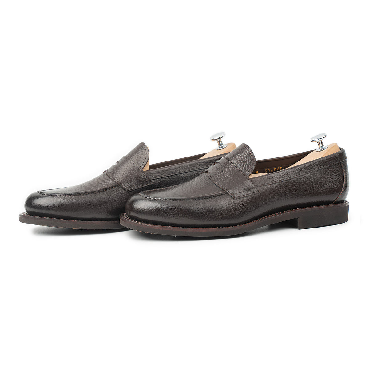 Meermin brown INCA grain penny loafers on shoe trees, three-quarter side view showing apron stitching and diamond latex rubber sole