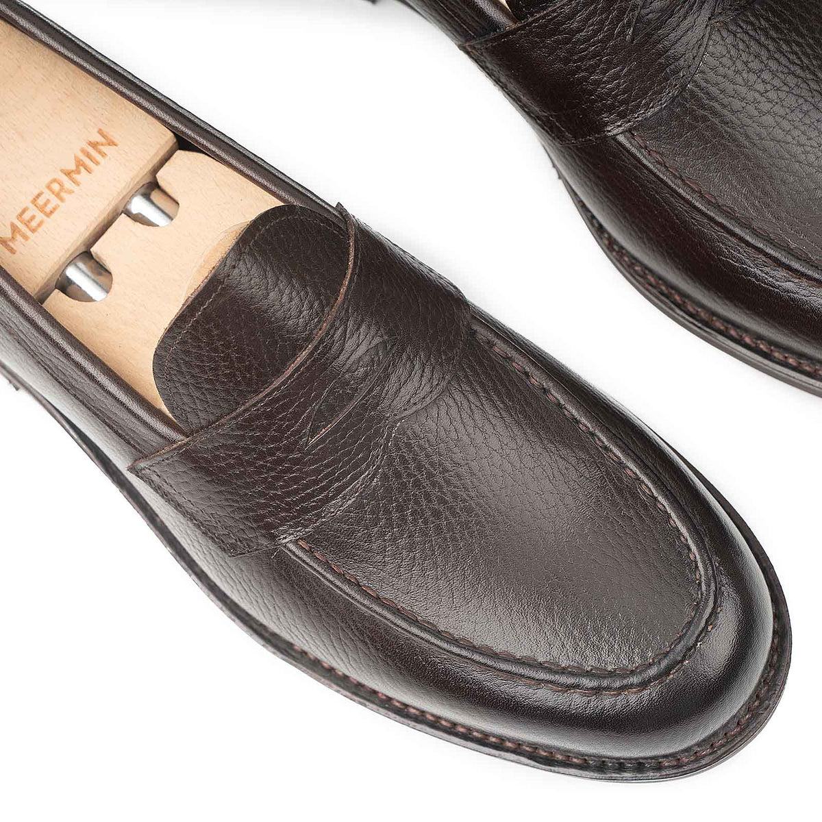 Meermin brown INCA grain penny loafers, close-up on apron stitching and toe with wooden shoe trees inserted