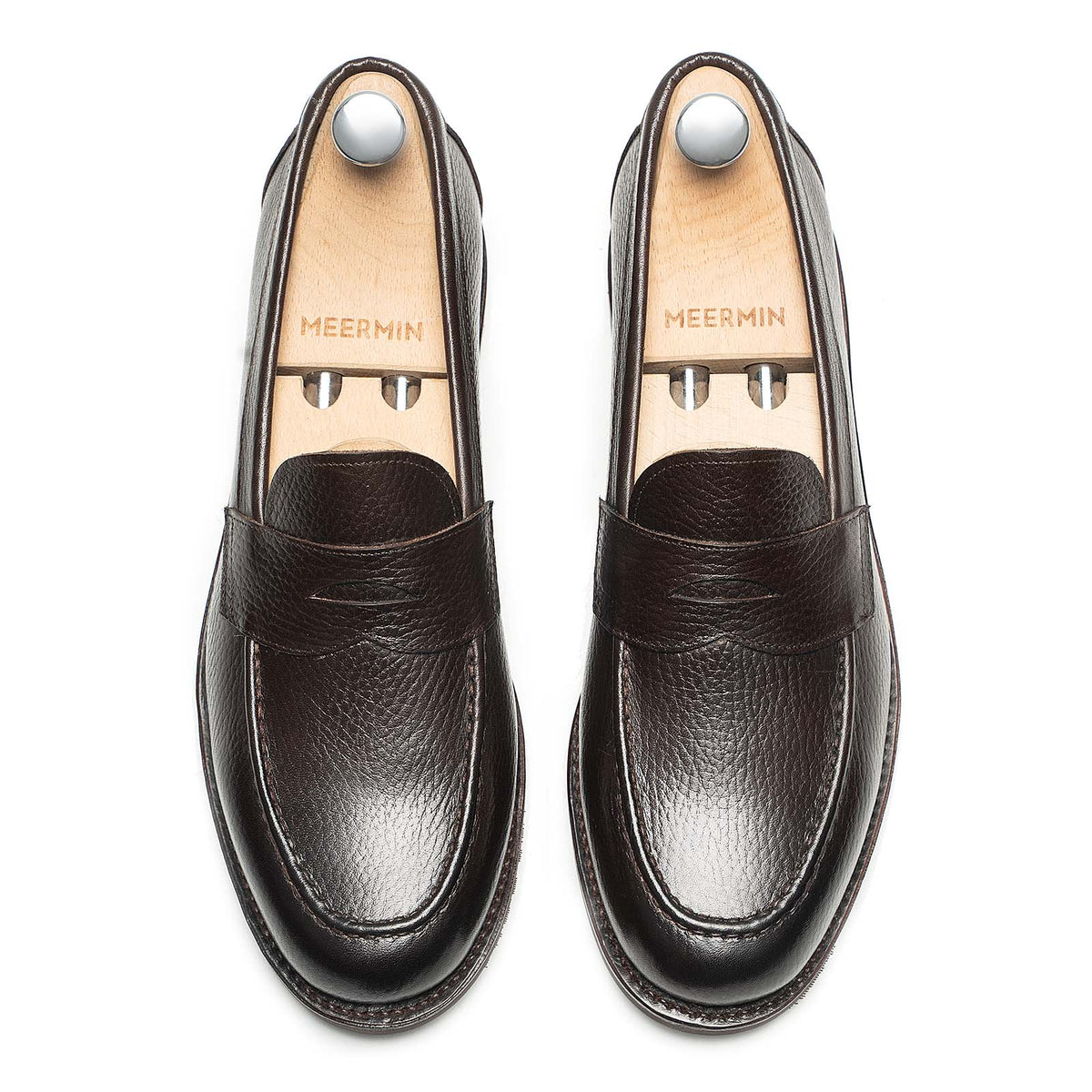 Meermin brown INCA grain penny loafers, top-down view on shoe trees, showing textured leather and apron stitching
