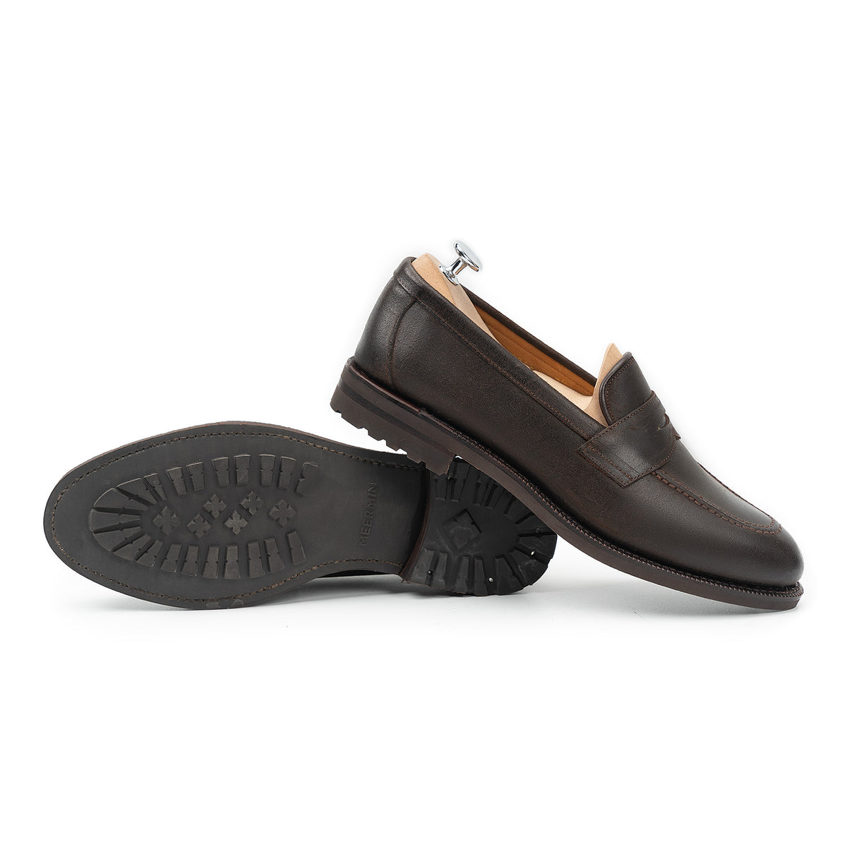 Meermin rust waxy Commander suede penny loafers, paired with soles shown, one shoe on a wooden shoe tree, lug rubber sole visible