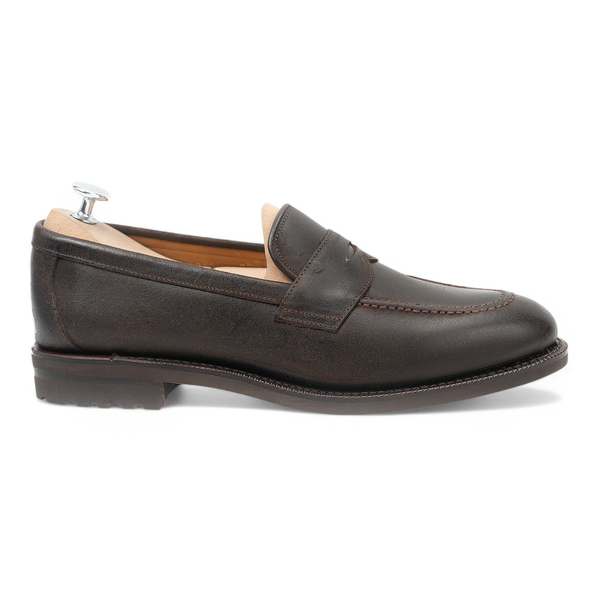 Meermin dark brown waxy commander penny loafer, side profile on a shoe tree, showing lug rubber sole and apron stitching