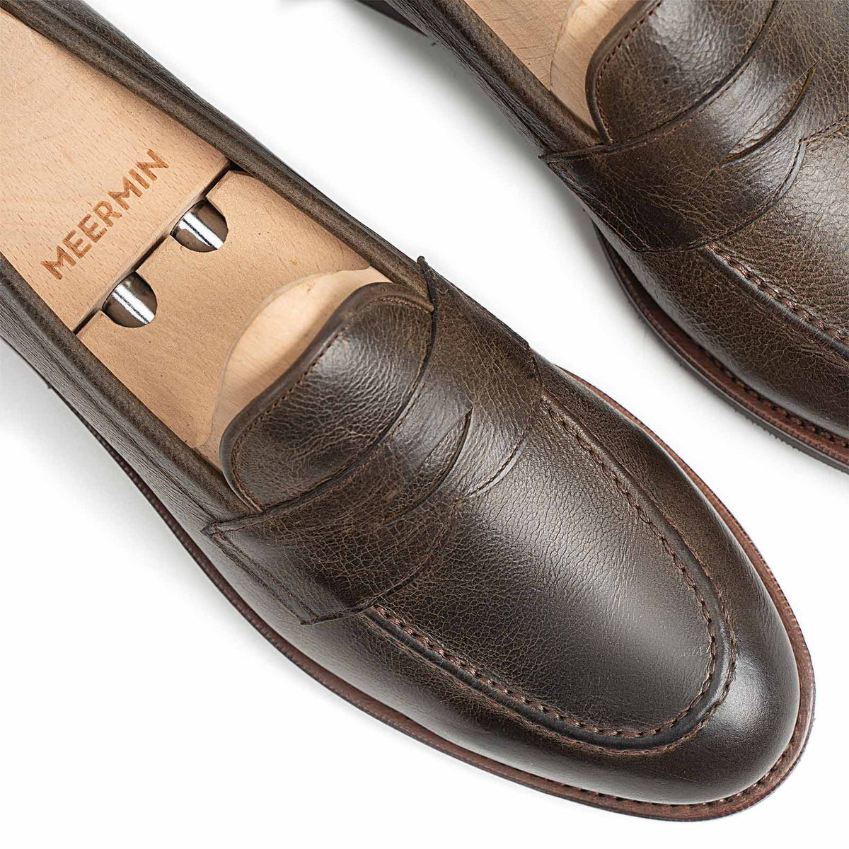 Meermin caper green naked kudu penny loafers on shoe trees, close-up of vamp and toe showing grain texture