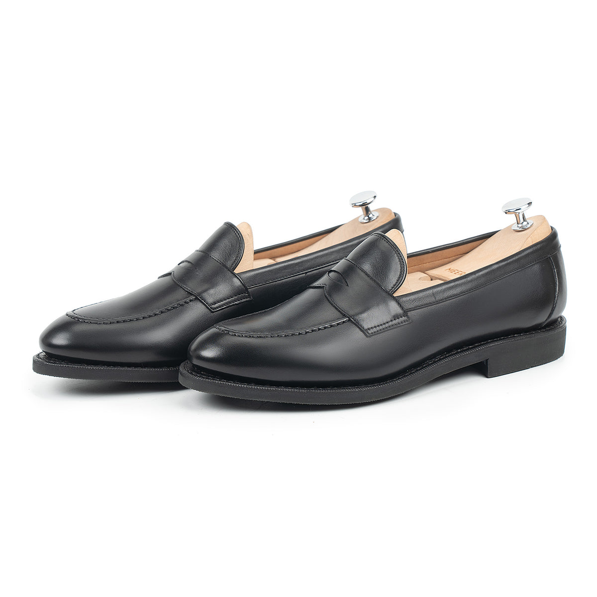 Meermin black silkcalf penny loafers, three-quarter view with shoe trees inserted, showing handsewn apron and diamond latex rubber sole
