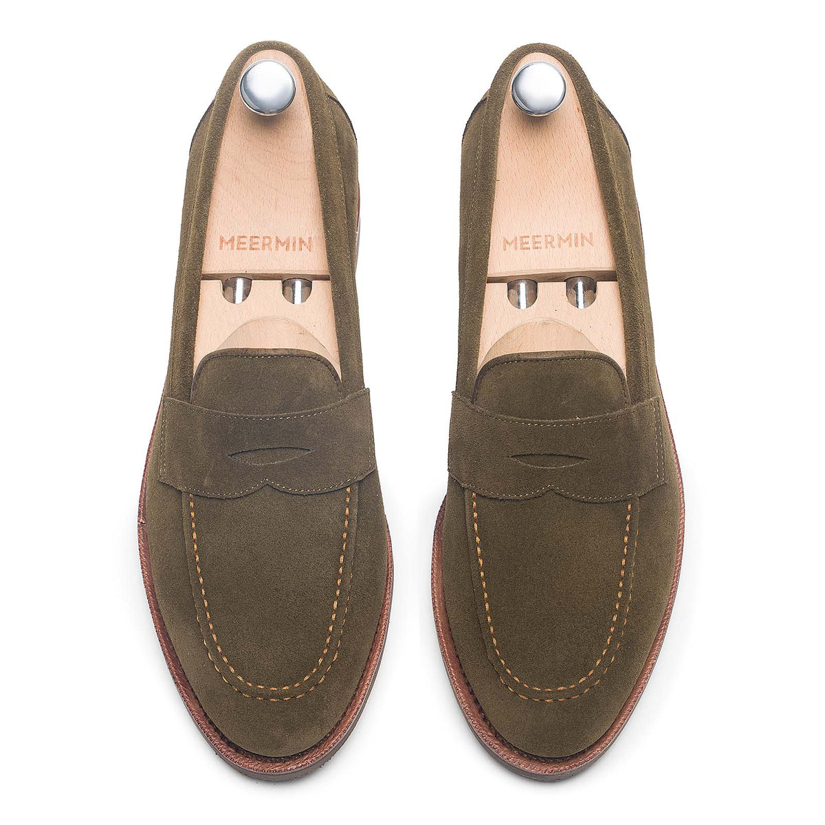 Meermin hunting green suede penny loafers, top-down view on shoe trees, showing saddle stitching and closed-channel sole edge