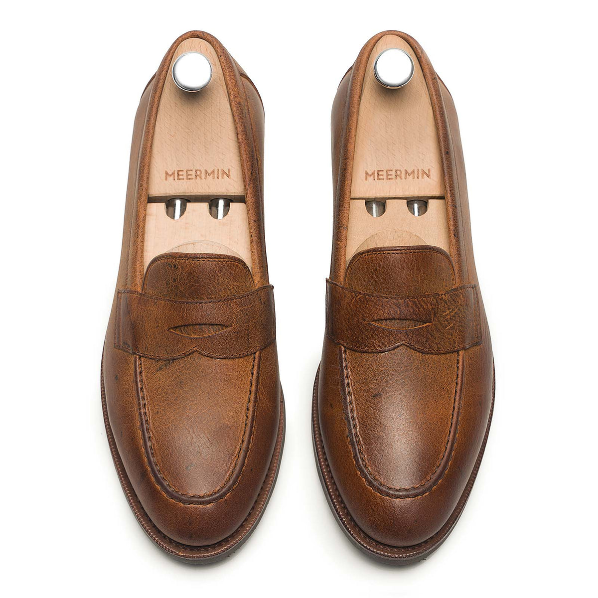 Meermin Autumn Spice waxy kudu penny loafers, top-down view on shoe trees, showing textured leather grain and stitched apron