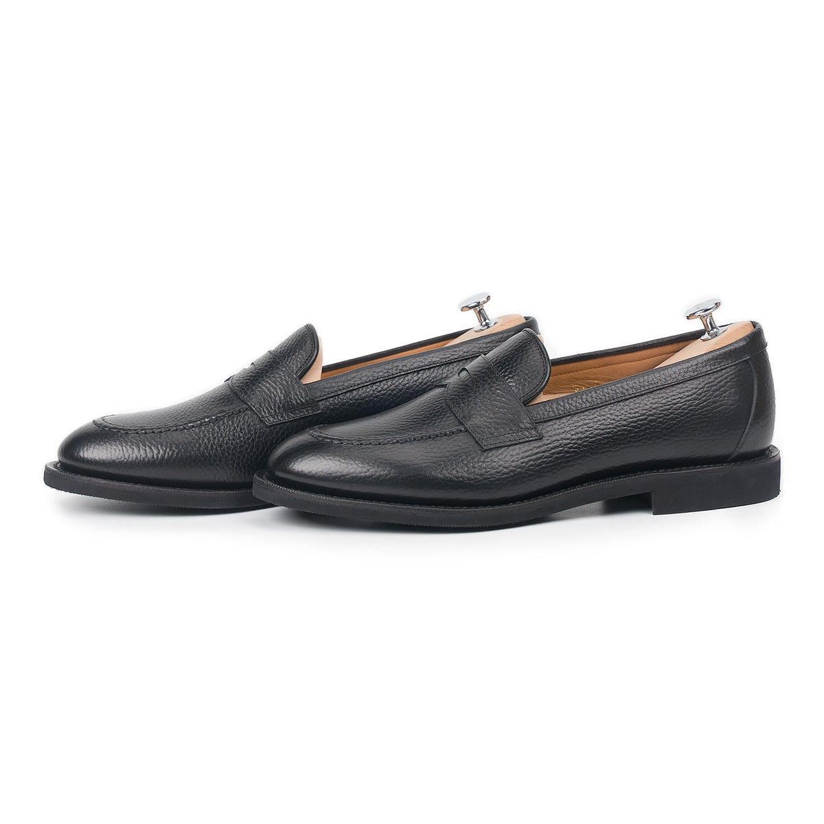 Meermin black Inca grain penny loafers, side-by-side profile view on shoe trees, showing handsewn apron and diamond rubber sole