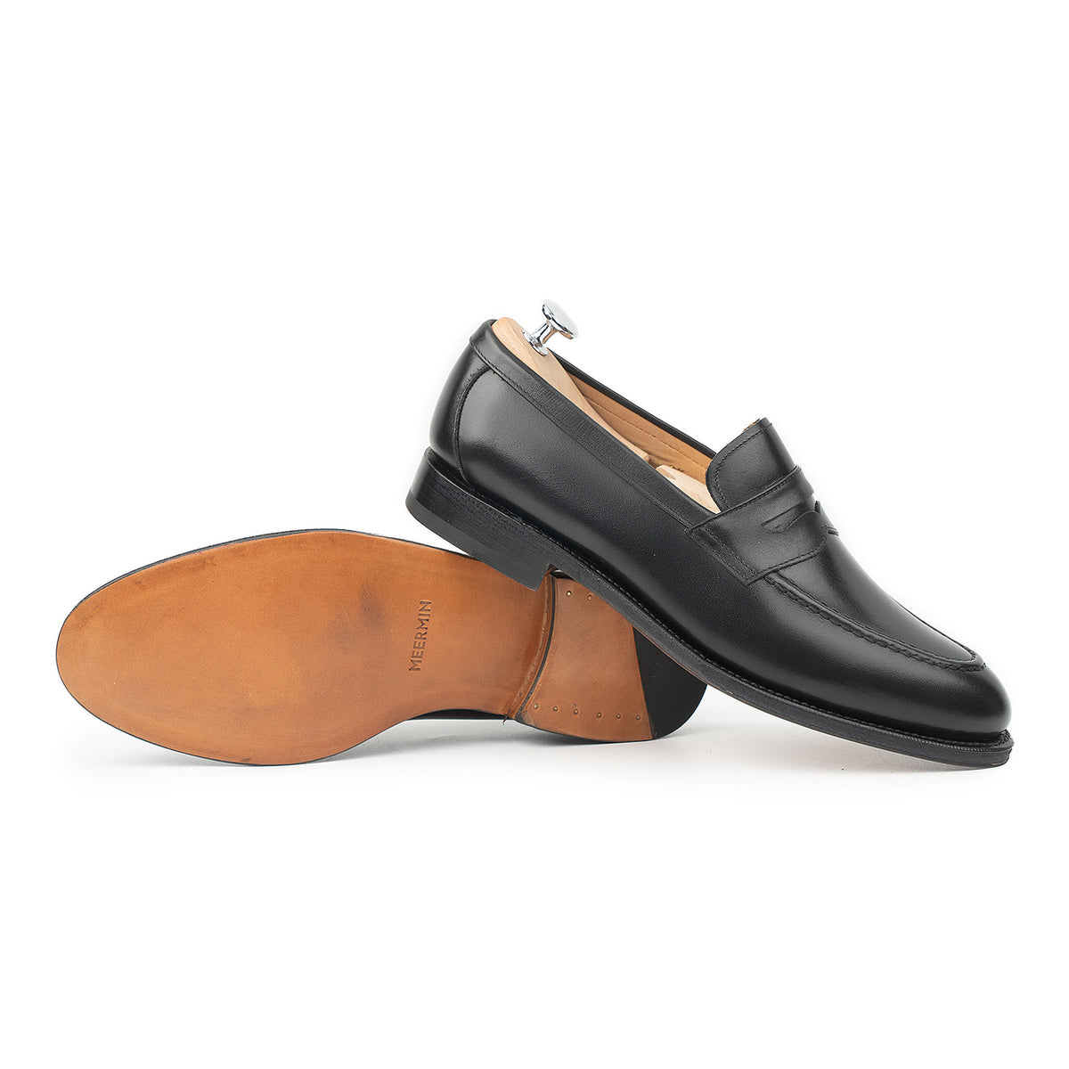 Meermin black boxcalf penny loafer, side profile with matching sole propped up showing tan leather insole and shoe tree in heel