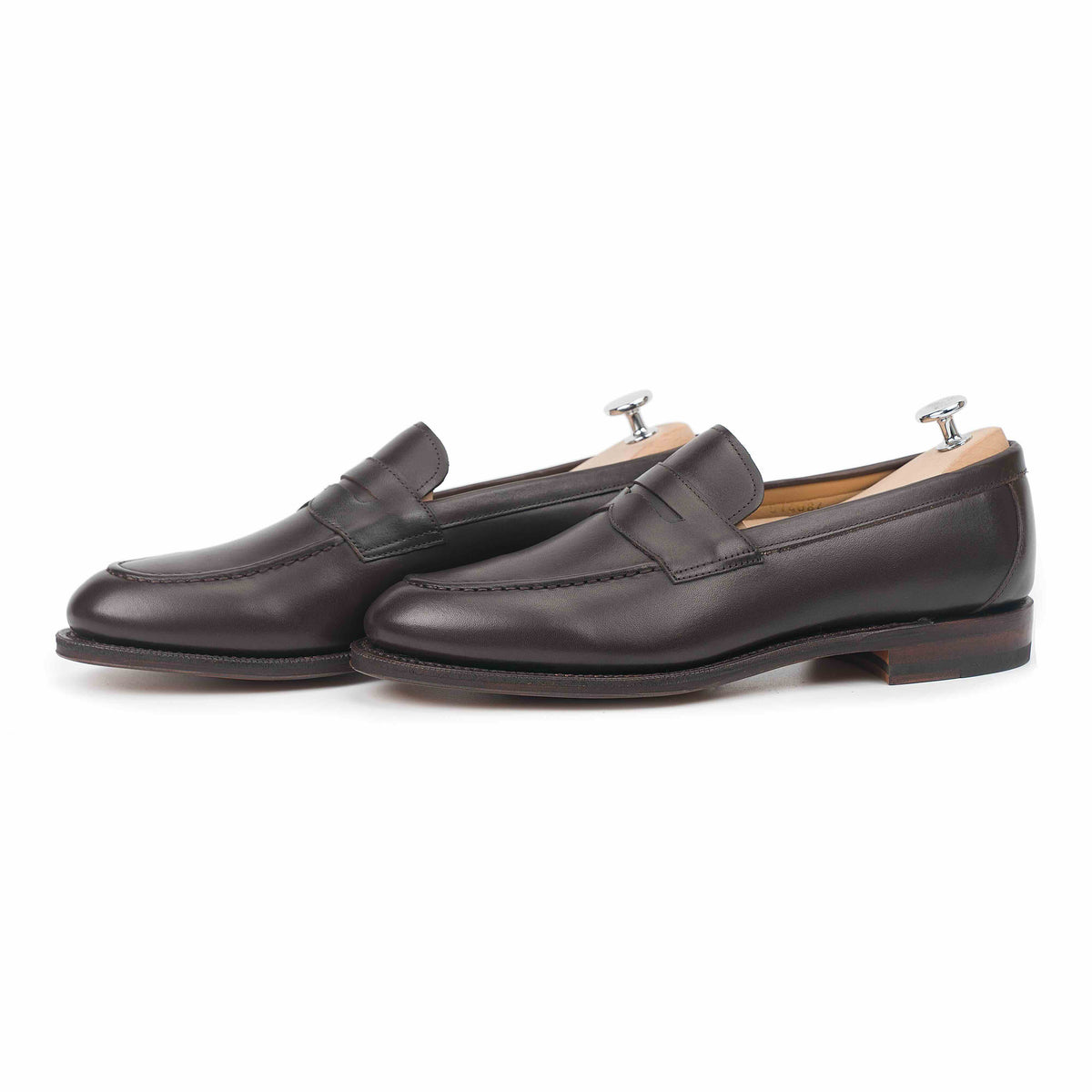 Meermin espresso antique calf penny loafers, side-by-side profile view on shoe trees, showing saddle strap and closed-channel leather sole