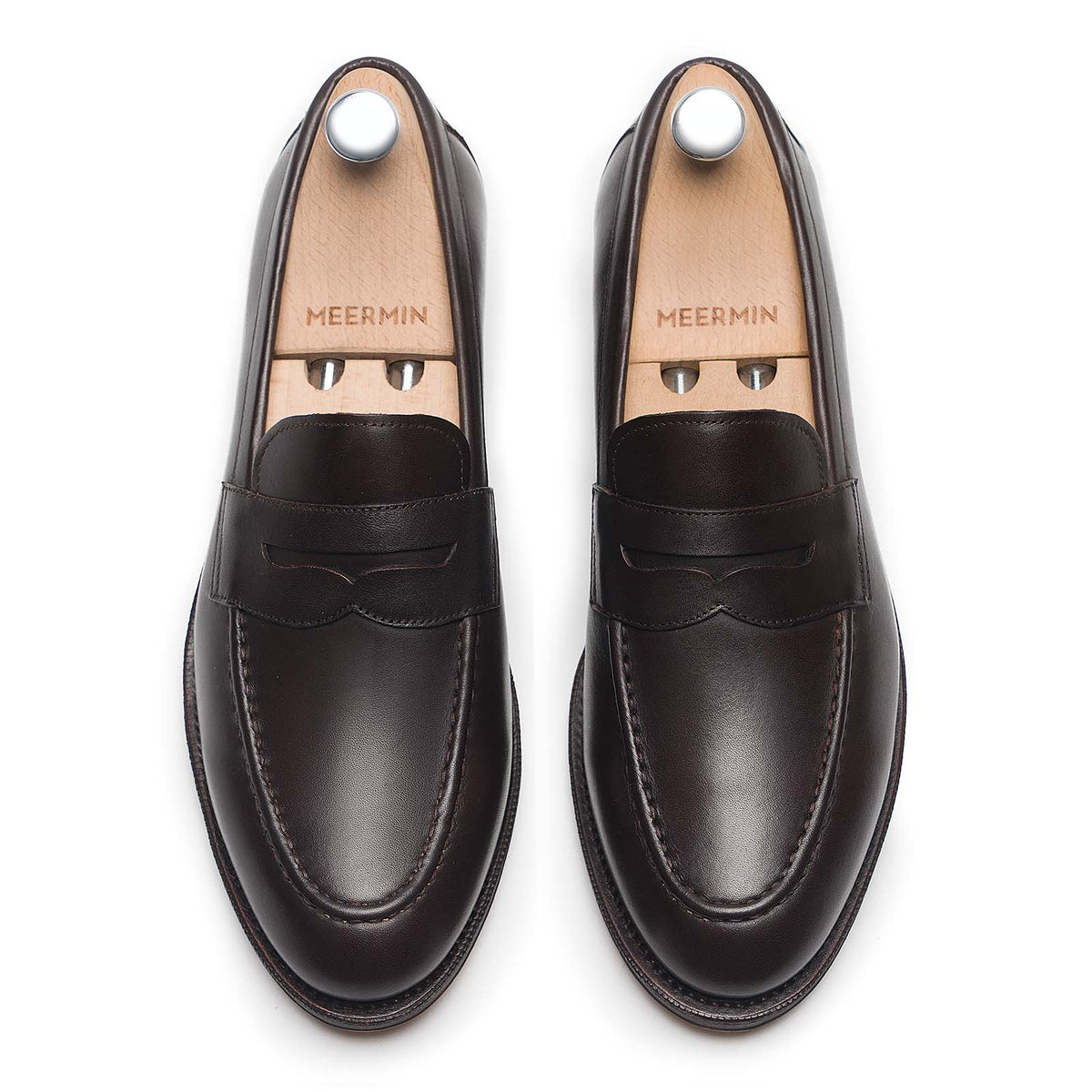 Meermin espresso antique calf penny loafers, top-down view on shoe trees, showing saddle strap and round toe shape