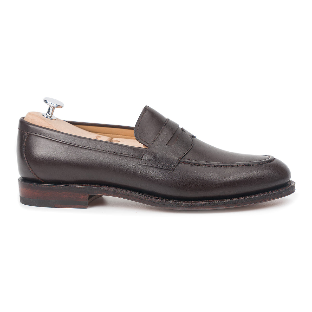 Meermin espresso antique calf penny loafer, side profile on a shoe tree, showing saddle strap and closed channel leather sole