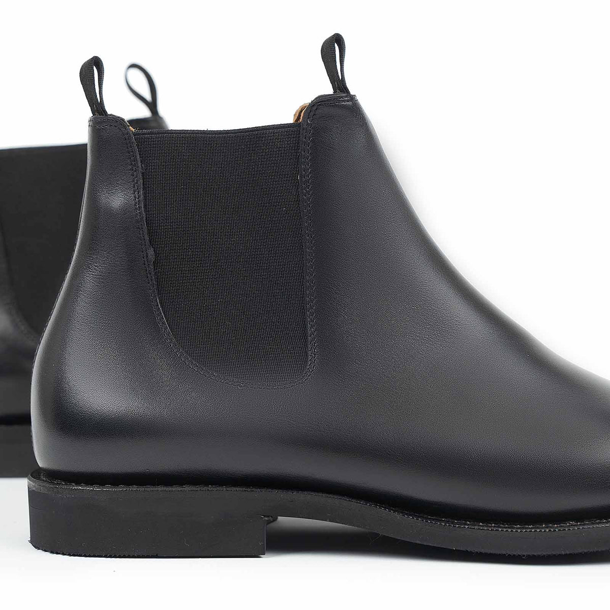 Meermin black silkcalf Chelsea boot, close-up rear view showing elastic side gore, pull tabs, and diamond latex rubber sole