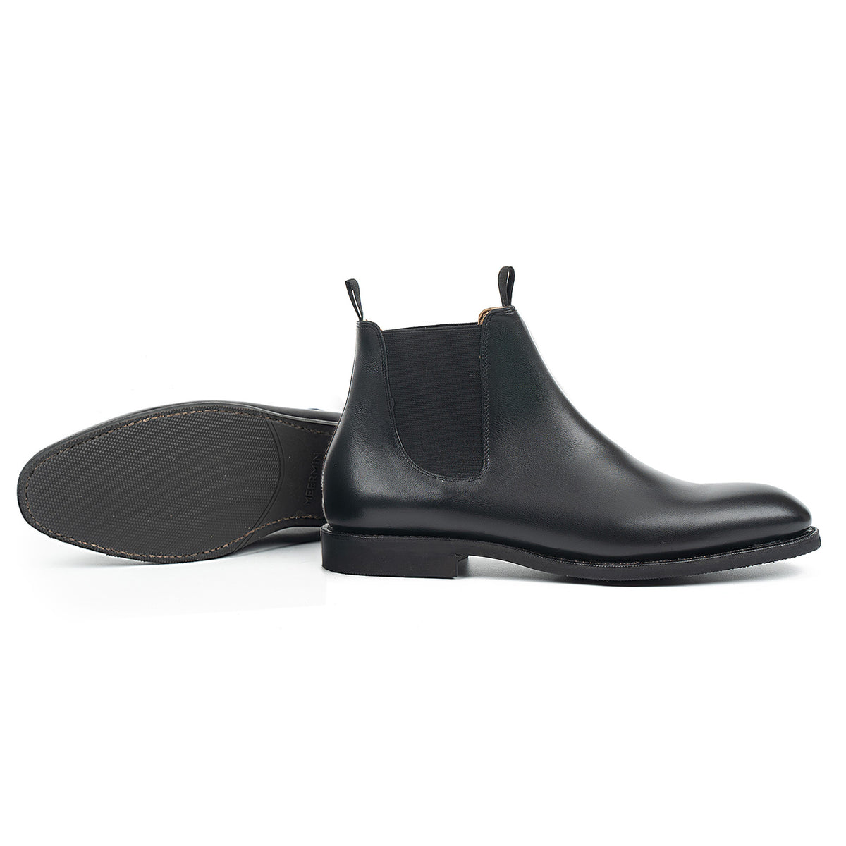 Meermin black silkcalf Chelsea boot, side profile paired with its mate lying sole-up, showing diamond latex rubber sole tread
