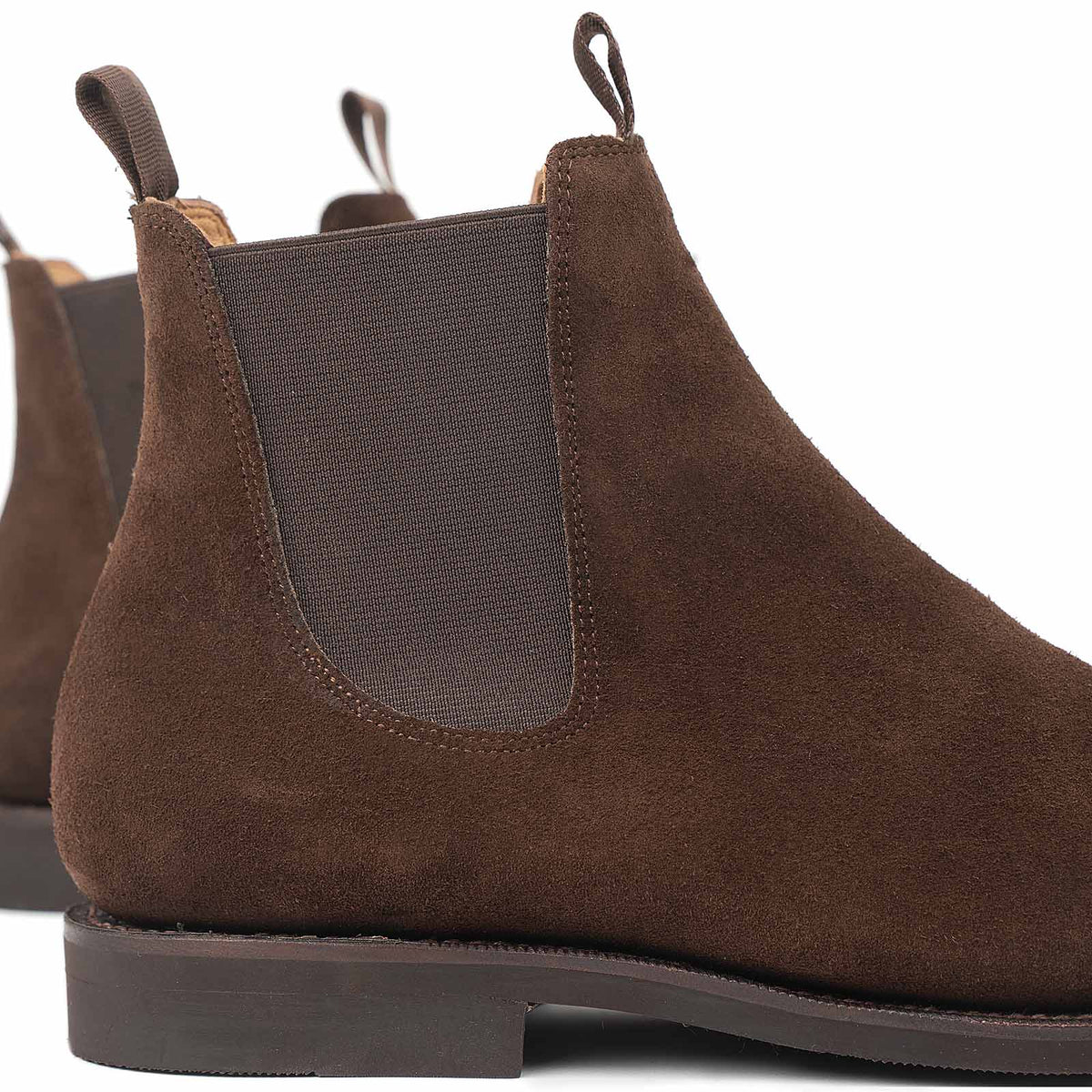 Close-up of Meermin brown Superbuck suede Chelsea boot, showing heel pull tab, elastic gusset, and stitched welt detail