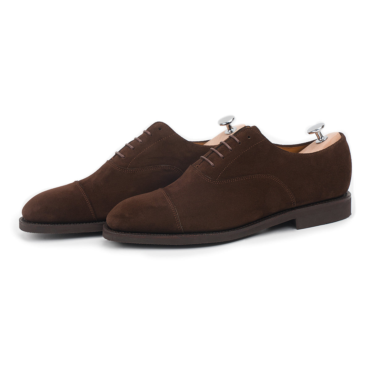 Meermin brown suede cap-toe Oxford pair, three-quarter side view with shoe trees inserted, showing diamond rubber sole edge