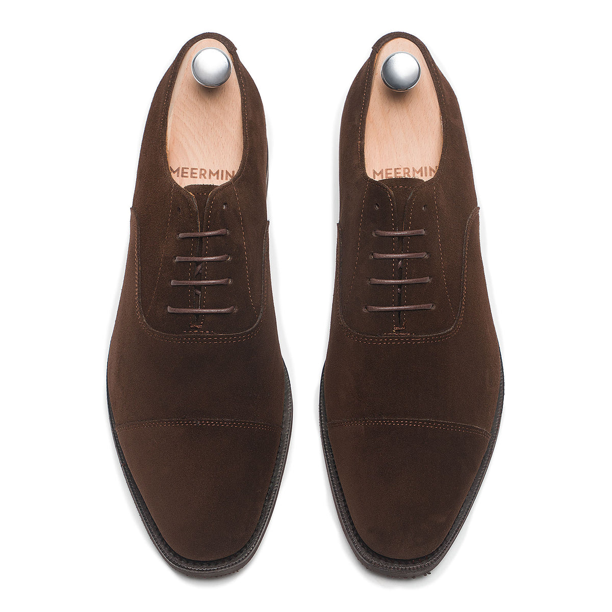 Meermin brown suede cap-toe Oxfords on shoe trees, top-down view of both shoes showing lacing and toe caps