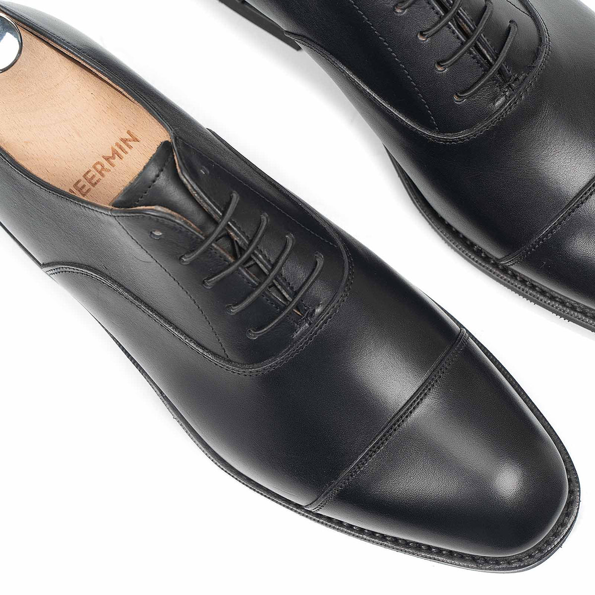 Meermin black silkcalf cap-toe Oxfords, close-up top view showing toe caps, lacing, and stitching detail on both shoes