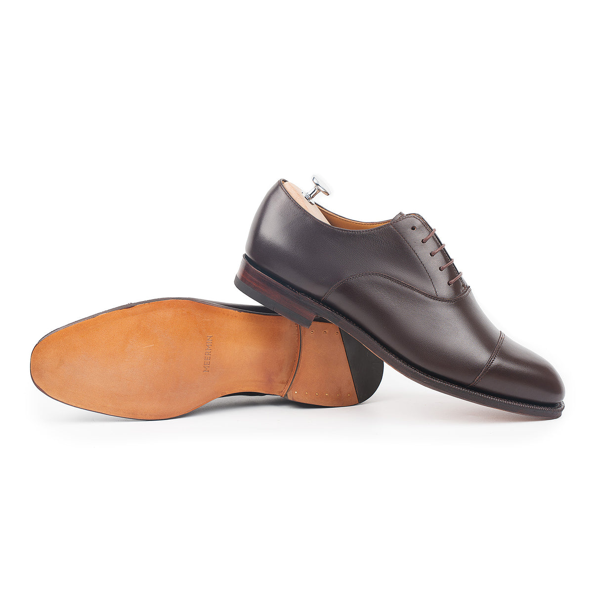 Meermin espresso antique calf cap-toe Oxford pair, one shoe upright on shoe tree, one tipped showing leather sole