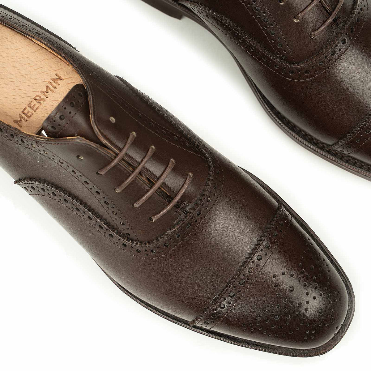 Close-up top view of Meermin brown boxcalf full brogue Oxfords, showing perforated cap-toe detailing, laces, and wooden shoe tree