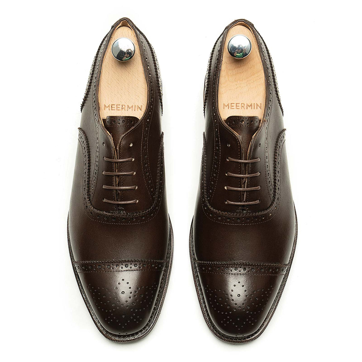 Meermin brown boxcalf full brogue Oxford pair, top-down view showing cap-toe perforation detail and shoe trees inserted