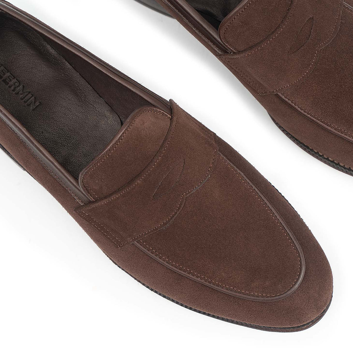 Meermin brown suede penny loafers, close-up top view showing piping apron detail and stitched saddle strap on both shoes